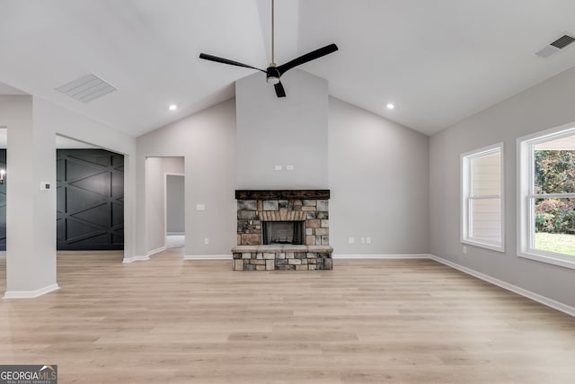 unfurnished living room featuring high vaulted ceiling, a fireplace, light wood-type flooring, and ceiling fan