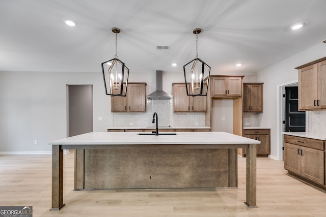 831 Banks Cir, Carrollton, GA 30116 - kitchen featuring wall chimney exhaust hood, a sink, tasteful backsplash, light wood-style floors, and recessed lighting