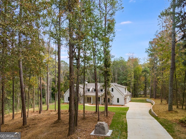 831 Banks Cir, Carrollton, GA 30116 - view of front facade featuring concrete driveway, a front lawn, and a wooded view