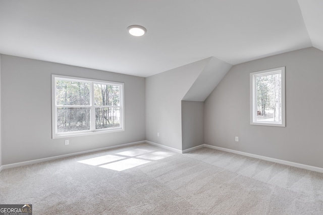 bonus room featuring vaulted ceiling and light colored carpet