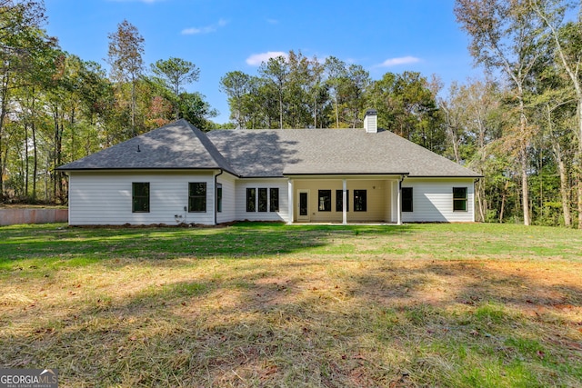 rear view of house featuring a lawn