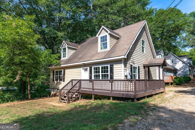 rear view of property with a yard and a deck