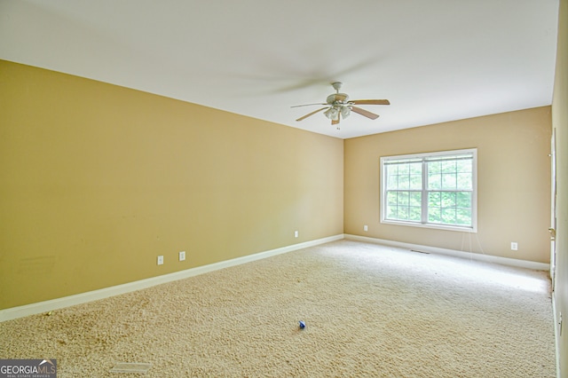 carpeted spare room featuring ceiling fan