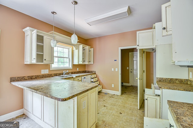 kitchen with pendant lighting, sink, light tile patterned floors, and kitchen peninsula