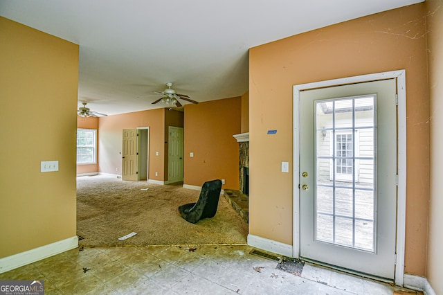 doorway with ceiling fan and tile patterned floors