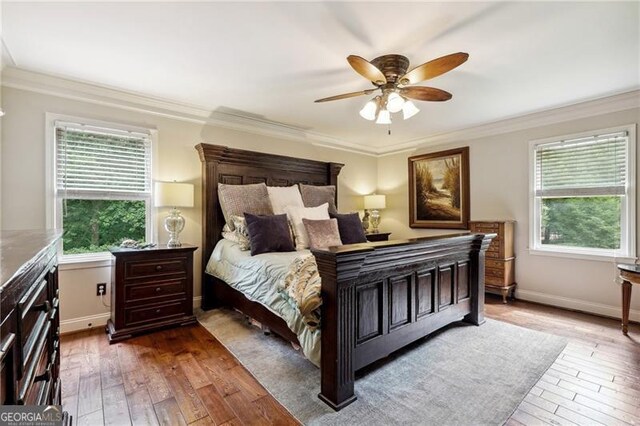 bedroom with ceiling fan, dark hardwood / wood-style flooring, and ornamental molding