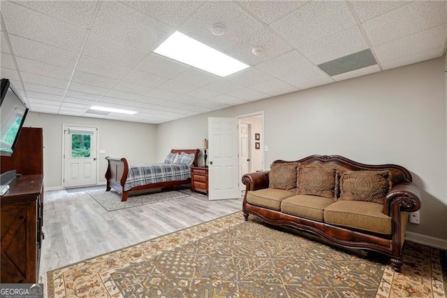 bedroom featuring a paneled ceiling and light hardwood / wood-style floors