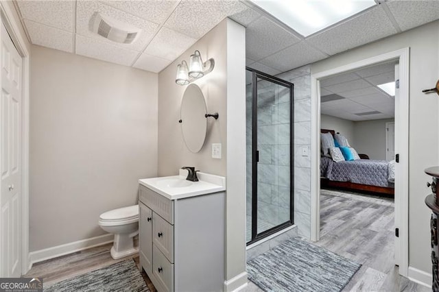 bathroom with walk in shower, vanity, toilet, hardwood / wood-style floors, and a paneled ceiling