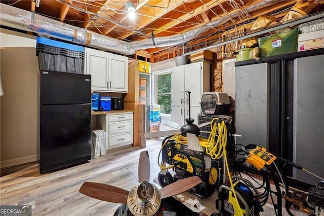 interior space featuring light wood-type flooring and black refrigerator