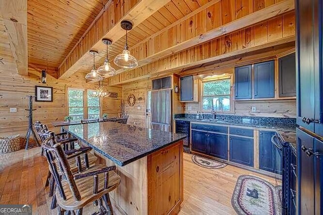 kitchen with wooden walls, light wood-type flooring, plenty of natural light, and a kitchen island