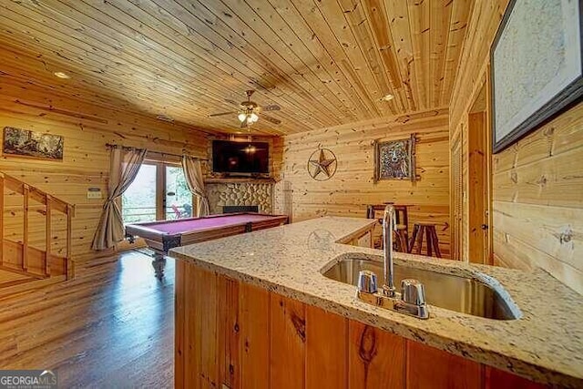 kitchen with wood ceiling, sink, wood walls, wood-type flooring, and billiards