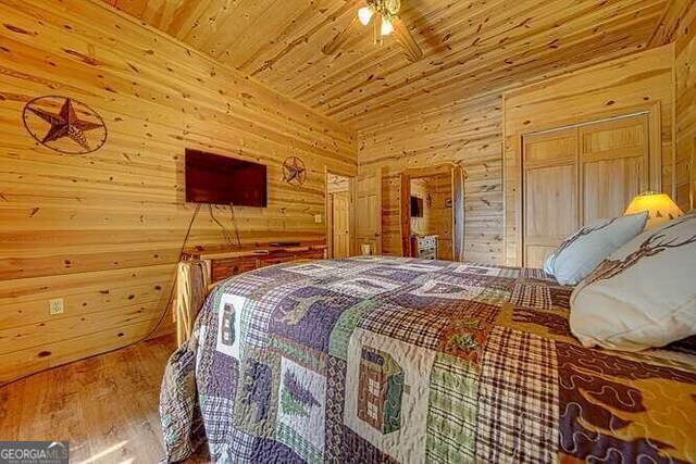 bedroom featuring wood walls, wooden ceiling, and wood-type flooring