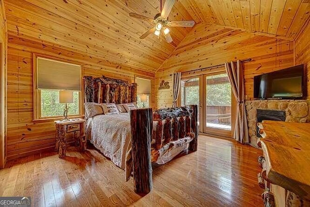 bedroom featuring wood walls, light hardwood / wood-style flooring, wooden ceiling, and access to exterior