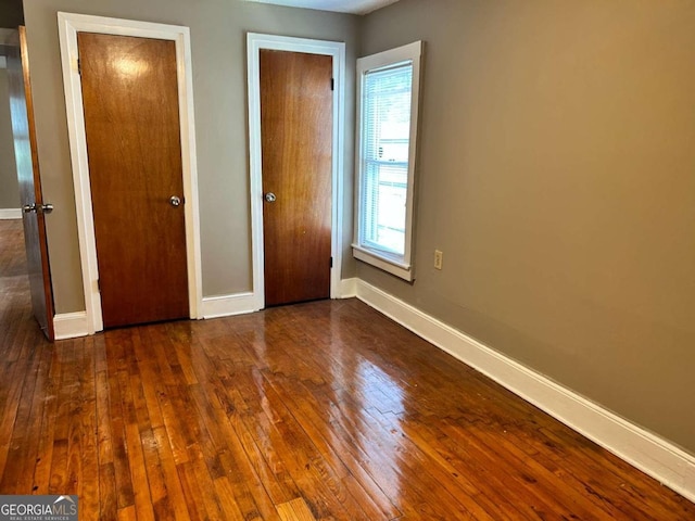 unfurnished bedroom featuring dark wood-type flooring