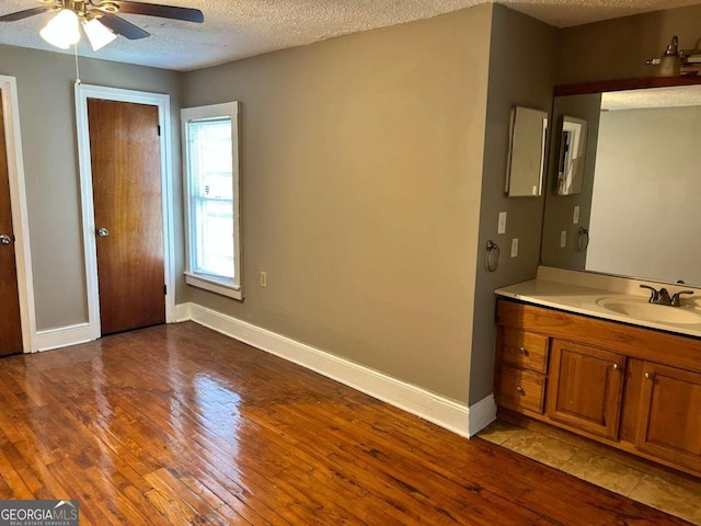 bathroom featuring vanity, a textured ceiling, hardwood / wood-style flooring, and ceiling fan