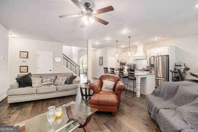 living room with ceiling fan and dark hardwood / wood-style flooring