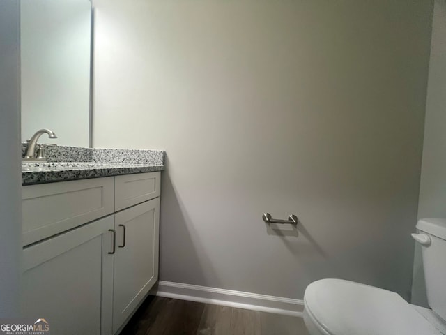 bathroom featuring vanity, toilet, and hardwood / wood-style flooring