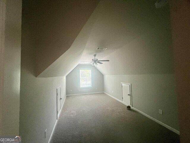 additional living space with vaulted ceiling, carpet, and ceiling fan