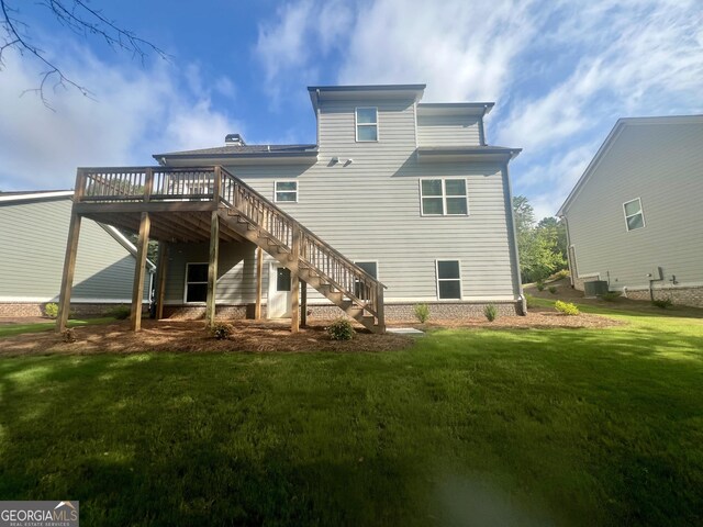 rear view of house with a deck and a lawn