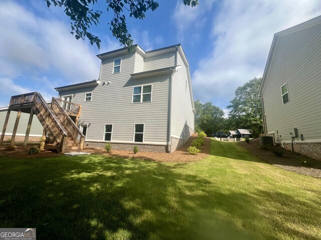 rear view of property with a deck and a yard