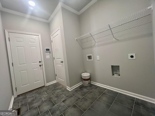 laundry area with electric dryer hookup, crown molding, dark tile patterned floors, and hookup for a washing machine