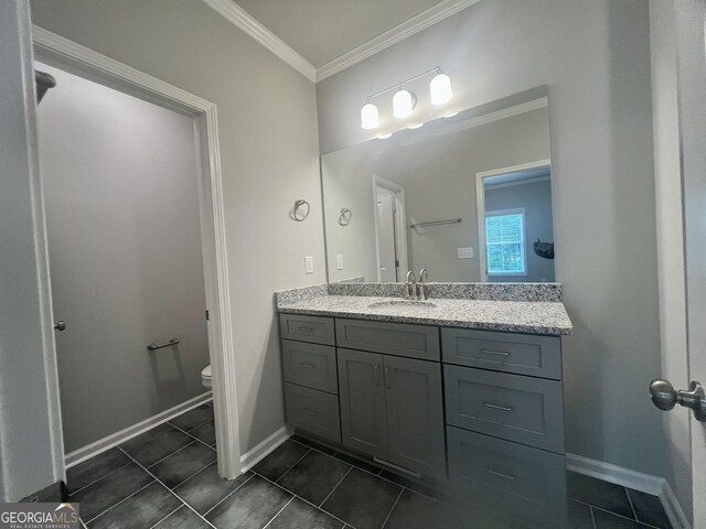 bathroom featuring tile patterned flooring, toilet, vanity, and ornamental molding