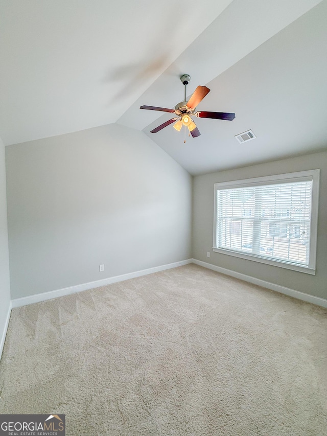 carpeted spare room featuring ceiling fan and lofted ceiling