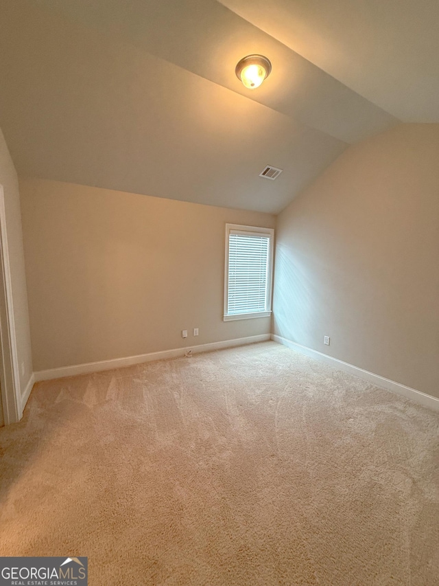 additional living space with vaulted ceiling and carpet flooring