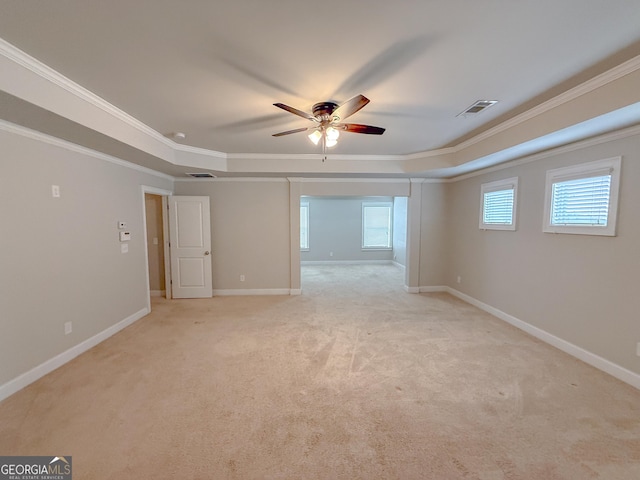 carpeted spare room with ornamental molding, a raised ceiling, and ceiling fan