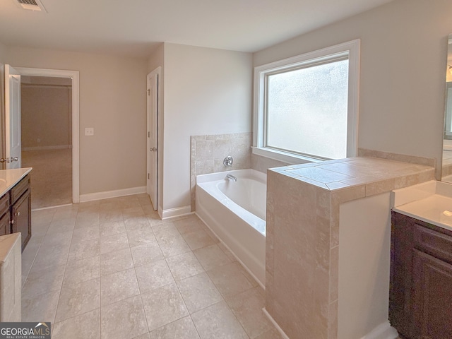 bathroom featuring vanity, tile patterned flooring, and a bathtub