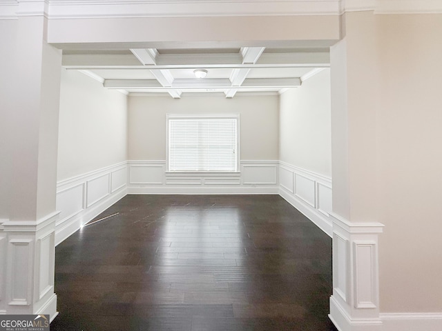 empty room featuring beamed ceiling, coffered ceiling, dark wood-type flooring, and crown molding