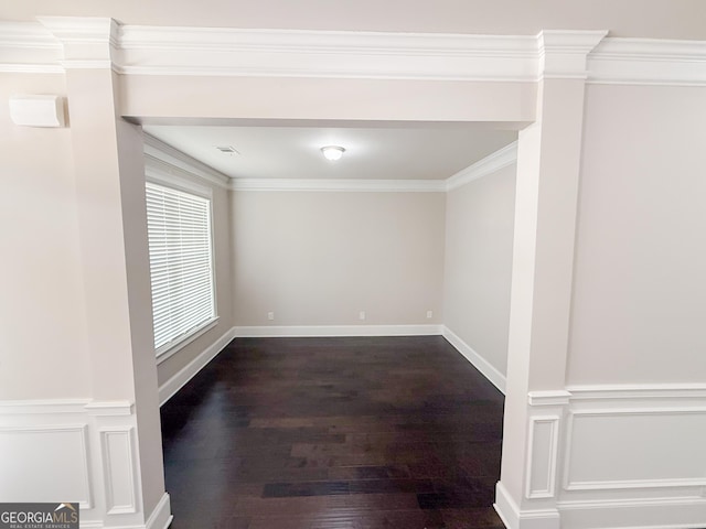 spare room with ornamental molding and dark hardwood / wood-style flooring