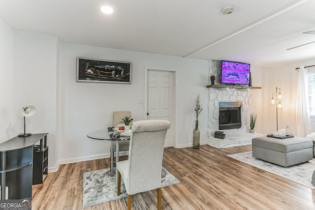 dining space with a stone fireplace and hardwood / wood-style flooring