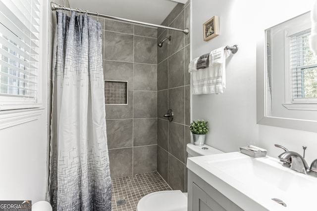 bathroom featuring vanity, toilet, and walk in shower