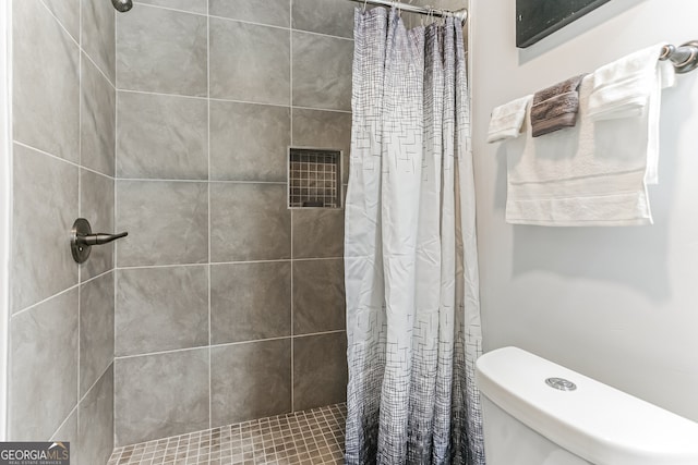 bathroom featuring toilet and a shower with shower curtain