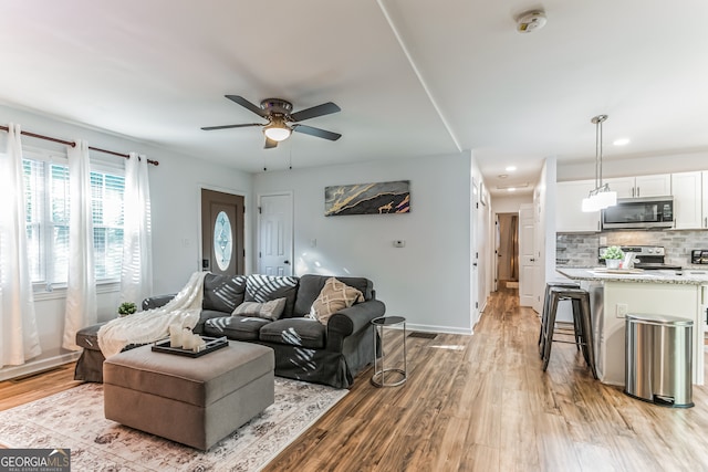 living room featuring ceiling fan and light hardwood / wood-style flooring