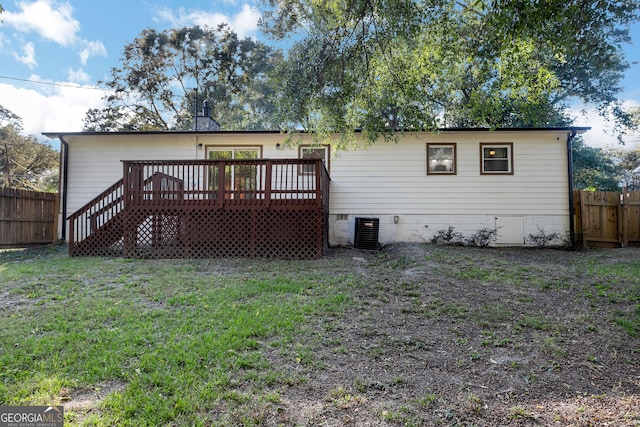 rear view of property featuring a yard, a wooden deck, and central AC unit