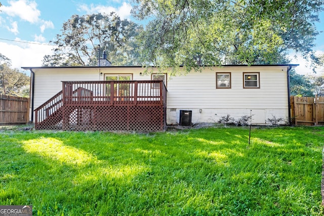 rear view of house featuring central AC unit, a wooden deck, and a lawn