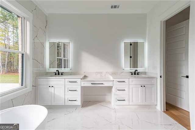 2861 Tree Top Rd, Dacula, GA 30019 - full bathroom featuring two vanities, plenty of natural light, a freestanding tub, and marble finish flooring