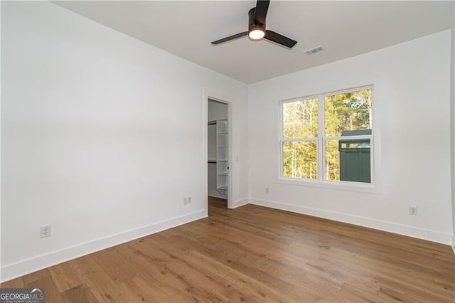 2861 Tree Top Rd, Dacula, GA 30019 - unfurnished bedroom featuring baseboards, wood finished floors, a spacious closet, and ceiling fan
