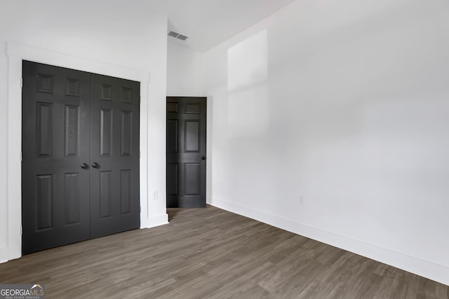 unfurnished bedroom with a closet and hardwood / wood-style floors