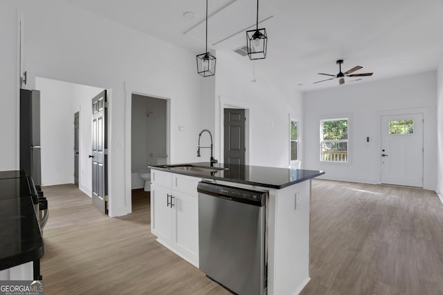 kitchen with a center island with sink, sink, white cabinets, pendant lighting, and appliances with stainless steel finishes