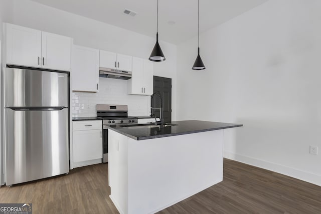 kitchen with a center island with sink, appliances with stainless steel finishes, hanging light fixtures, white cabinetry, and dark hardwood / wood-style floors