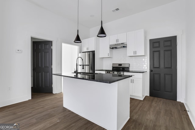 kitchen with an island with sink, hanging light fixtures, stainless steel appliances, white cabinets, and dark hardwood / wood-style floors