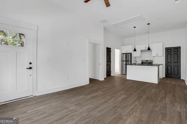 unfurnished living room featuring sink, dark wood-type flooring, and ceiling fan