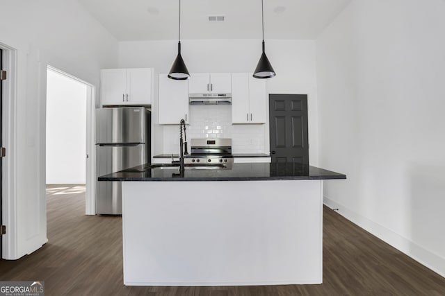 kitchen with a kitchen island with sink, dark hardwood / wood-style floors, dark stone countertops, white cabinets, and appliances with stainless steel finishes