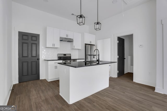 kitchen with white cabinets, an island with sink, appliances with stainless steel finishes, sink, and decorative light fixtures