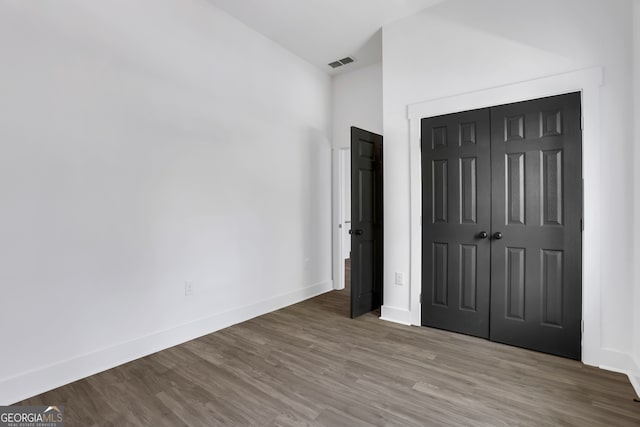 unfurnished bedroom featuring wood-type flooring and a closet