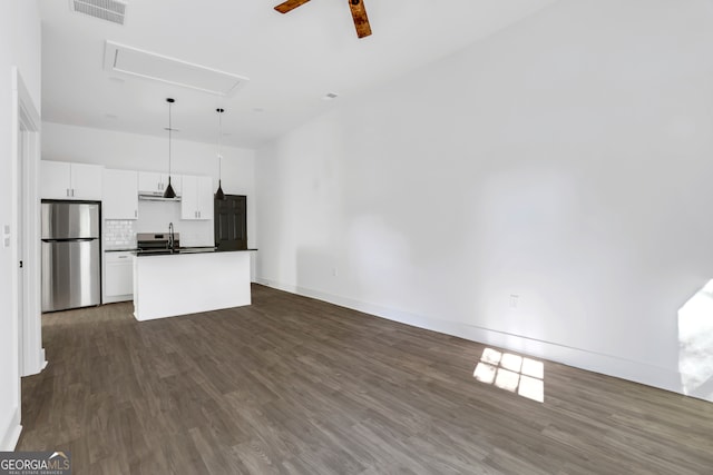 unfurnished living room featuring ceiling fan and dark hardwood / wood-style flooring