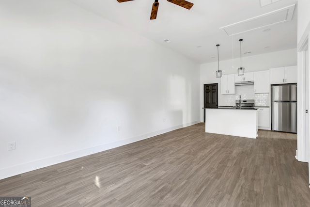 unfurnished living room featuring ceiling fan, sink, and hardwood / wood-style floors